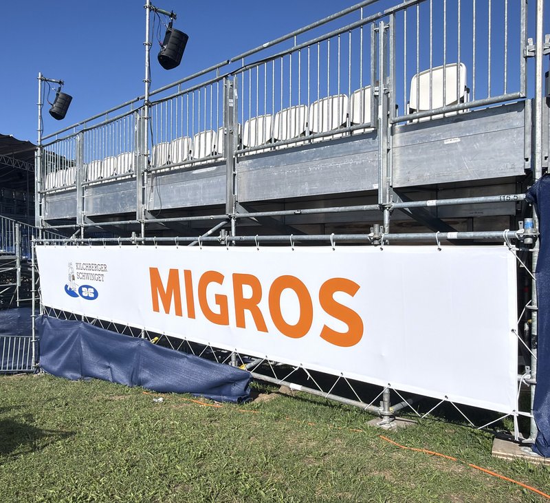 Nahaufnahme Sponsorenblache Migros und an der Tribüne der 18. Kilchberger Schwinget.