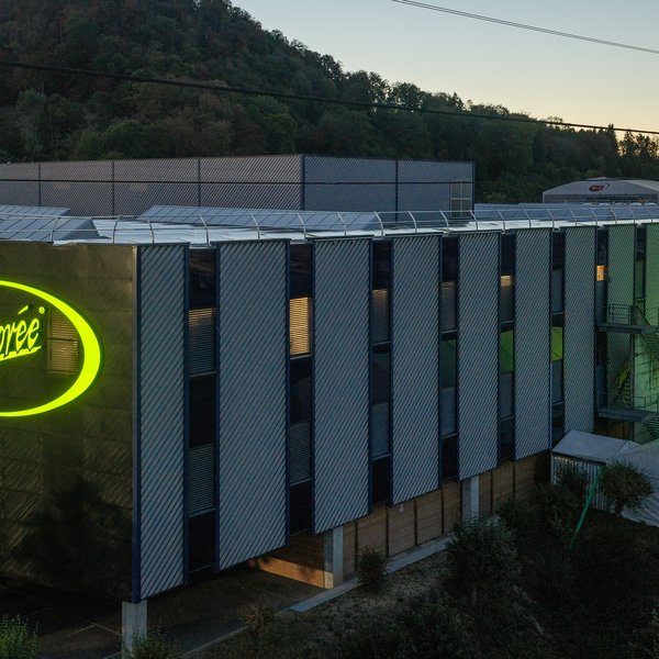 Huge illuminated “Chicorée” logos on two sides of the central warehouse in Brunegg.
