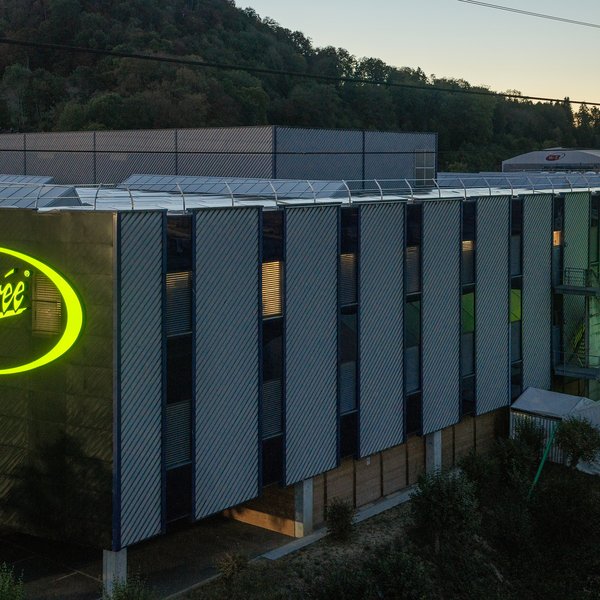 D'immenses logos lumineux « Chicorée » sur deux côtés de la façade de l'entrepôt central de Brunegg.