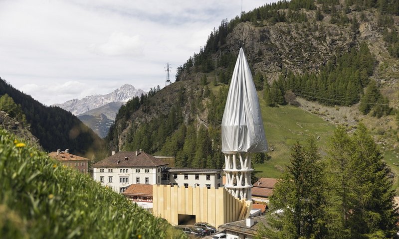 Ein Helikopter enthüllt den Weissen Turm von Mulegns mit einer 25 Meter langen Textilhülle.