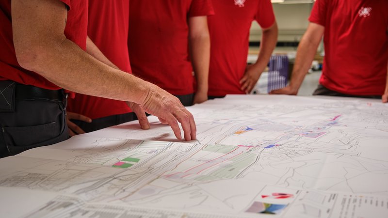 Des collaborateurs planifient le montage des bâches et tissus imprimés pour l’ESAF 2025 sur le site du festival.
