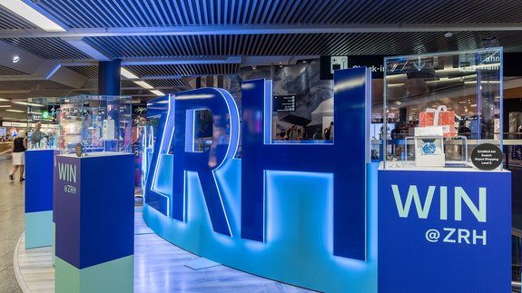 Begehbare Markeninszenierung mit LED-Wall und Acrylglas-Buchstaben im Flughafen Zürich, gestaltet als interaktive Erlebniswelt.