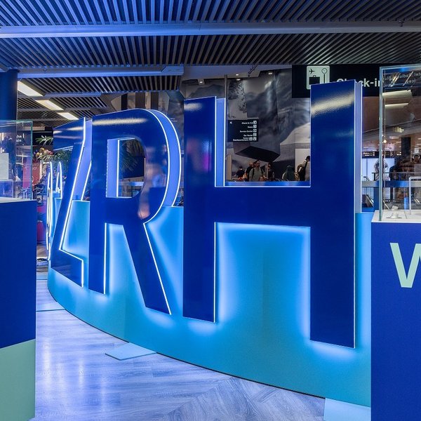 Walkable brand staging with LED wall and acrylic letters at Zurich Airport, designed as an interactive experience world.
