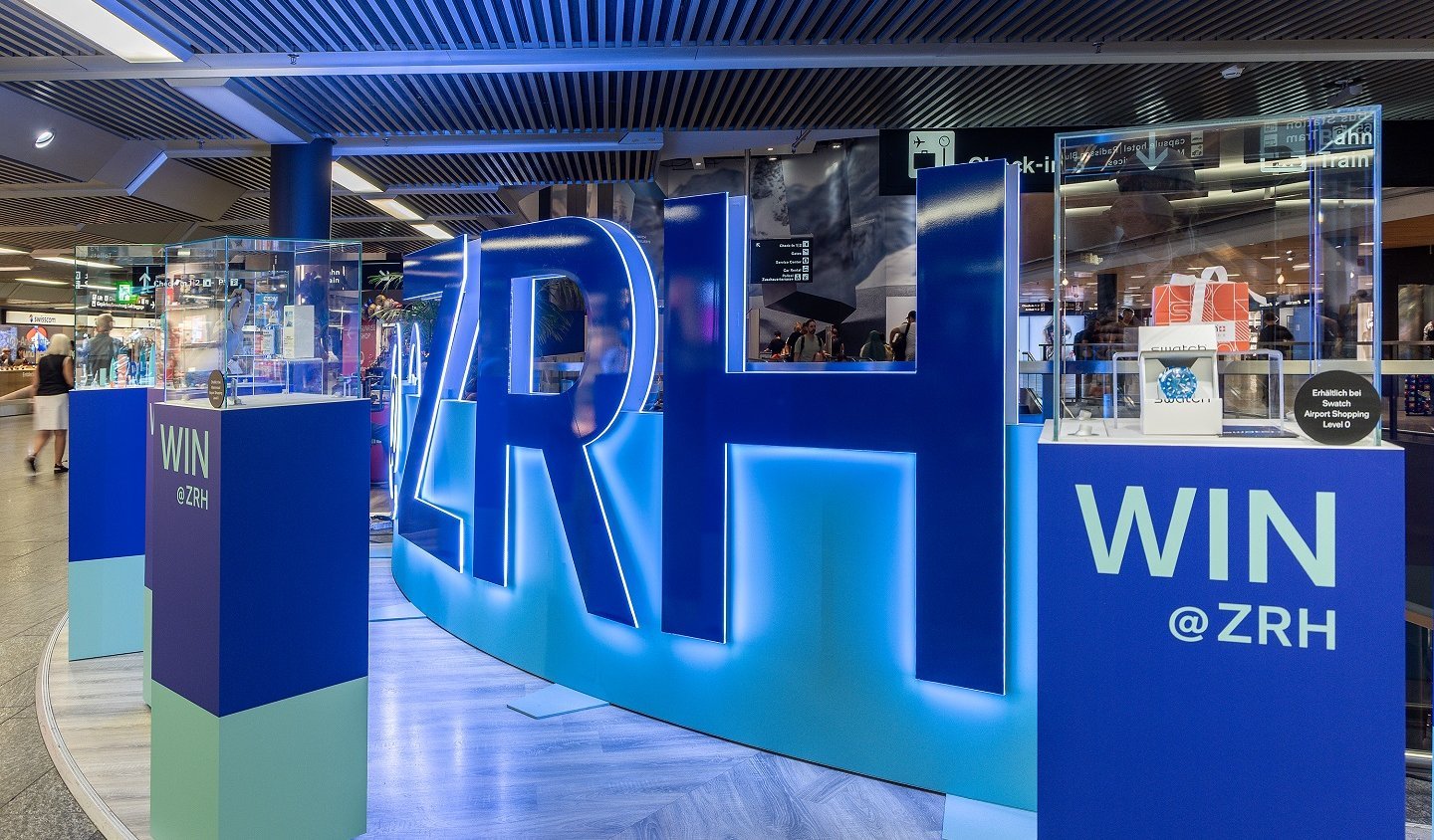 Walkable brand staging with LED wall and acrylic letters at Zurich Airport, designed as an interactive experience world.