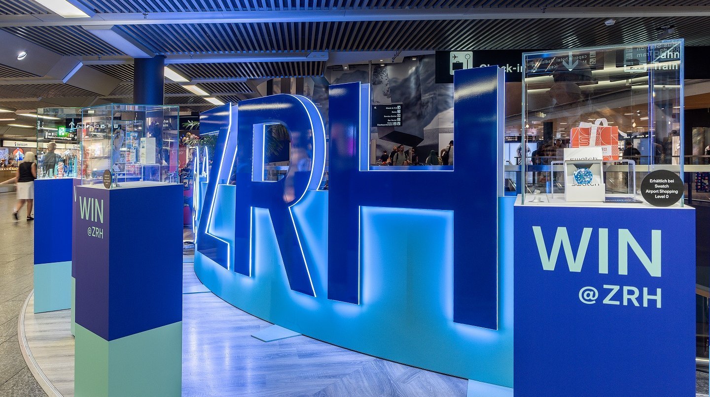 Begehbare Markeninszenierung mit LED-Wall und Acrylglas-Buchstaben im Flughafen Zürich, gestaltet als interaktive Erlebniswelt.