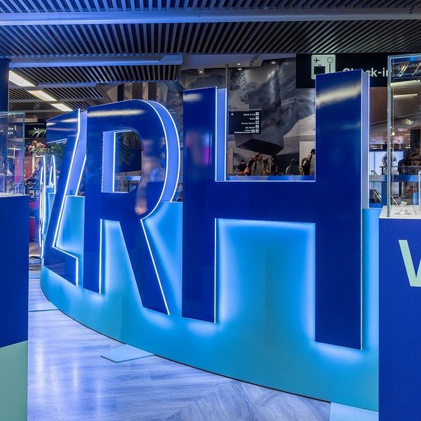 Begehbare Markeninszenierung mit LED-Wall und Acrylglas-Buchstaben im Flughafen Zürich, gestaltet als interaktive Erlebniswelt.