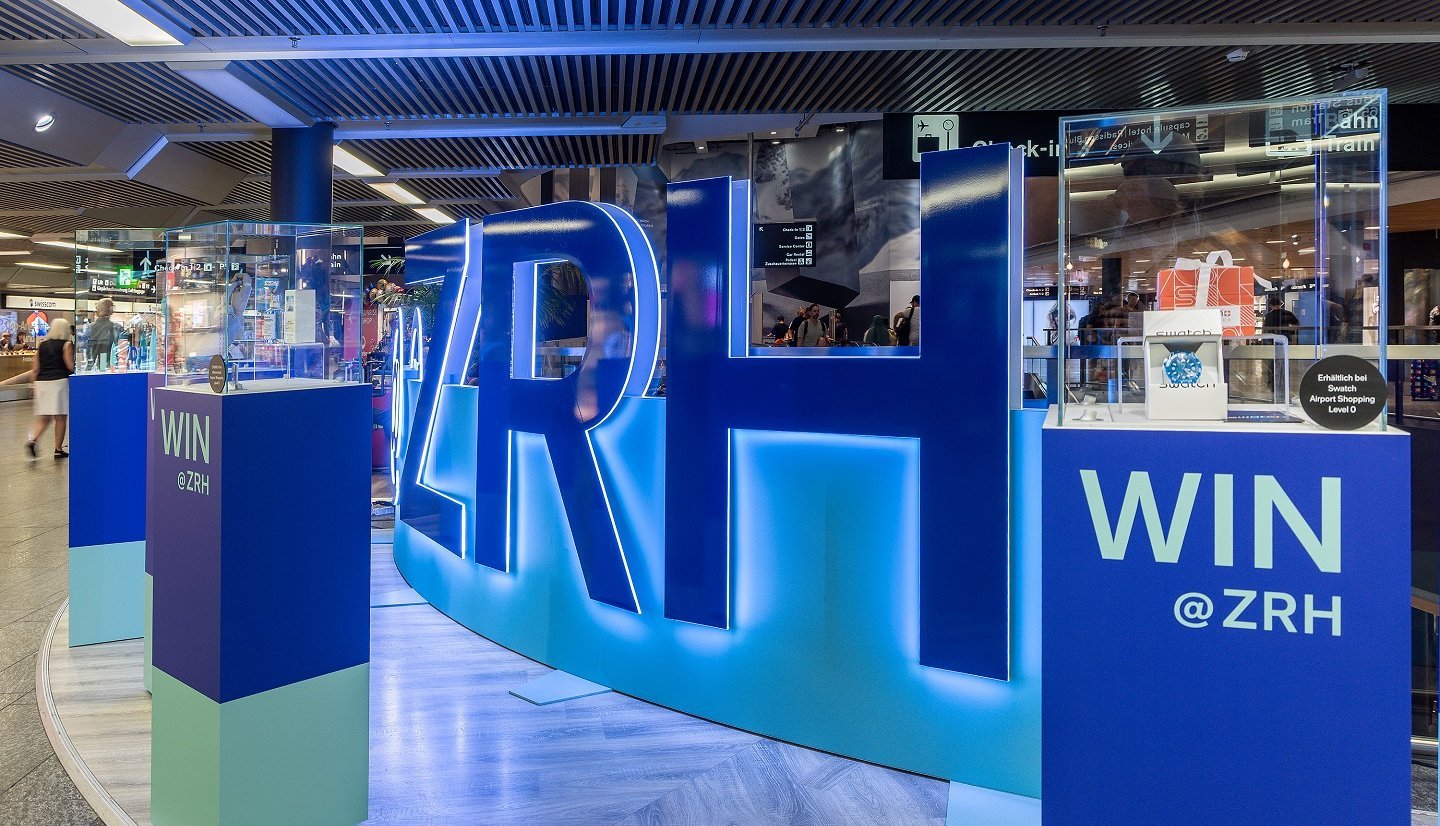 Mise en scène de marque immersive avec LED-Wall et lettres en acrylique à l’aéroport de Zurich, conçue comme un univers interactif.