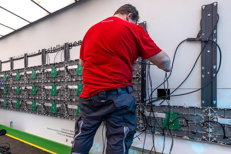 Installation eines hochauflösenden LED-Megascreens im Eingangsbereich des Museums Rietberg im Gebäude Smaragd, eingebettet in einen eleganten Metallrahmen.