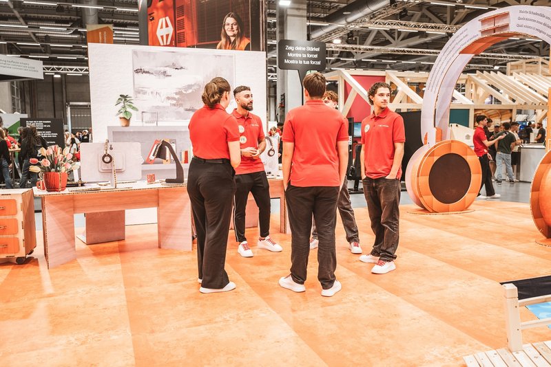 SwissSkills Messestand aus Wabenkarton. Die Mobiliar hat 300 m2 Messestand aus diesem Material gefertigt. Bis auf ein paar Ausnahmen wie Screens sind alle Elemente und Accessoires aus Karton. Team von die Mobiliar steht bereit, um die jungen Messebesuher zu empfangen.