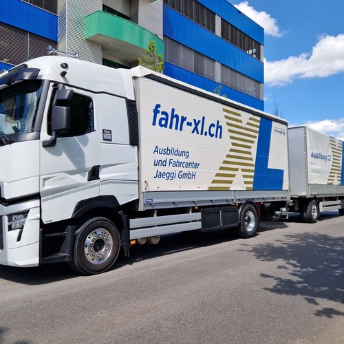 Neu von Richnerstutz schabloniertes LKW-Blachenverdeck für das Fahrcenter Jaeggi GmbH. Frontal-seitliche Ansicht, mit Fahrerkabine.