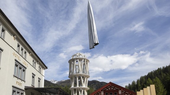 Der Weisse Turm von Mulegns wird mithilfe eines Helikopters von seiner textilen Hülle enthüllt.