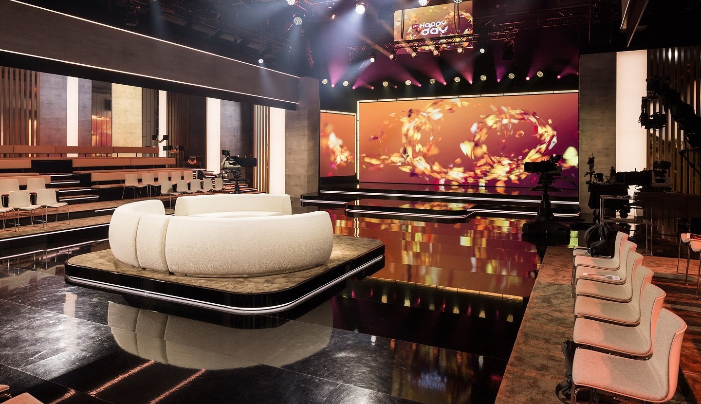 Caissons lumineux et éléments textiles dans le nouveau studio « Happy Day » de la SRF avec un éclairage précis et une conception moderne. Source de l'image : SRF