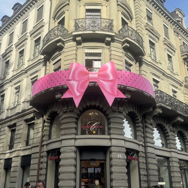 Rosa Riesenschleife am Balkongeländer des Flagship-Stores der Confiserie Bachmann in Zürich