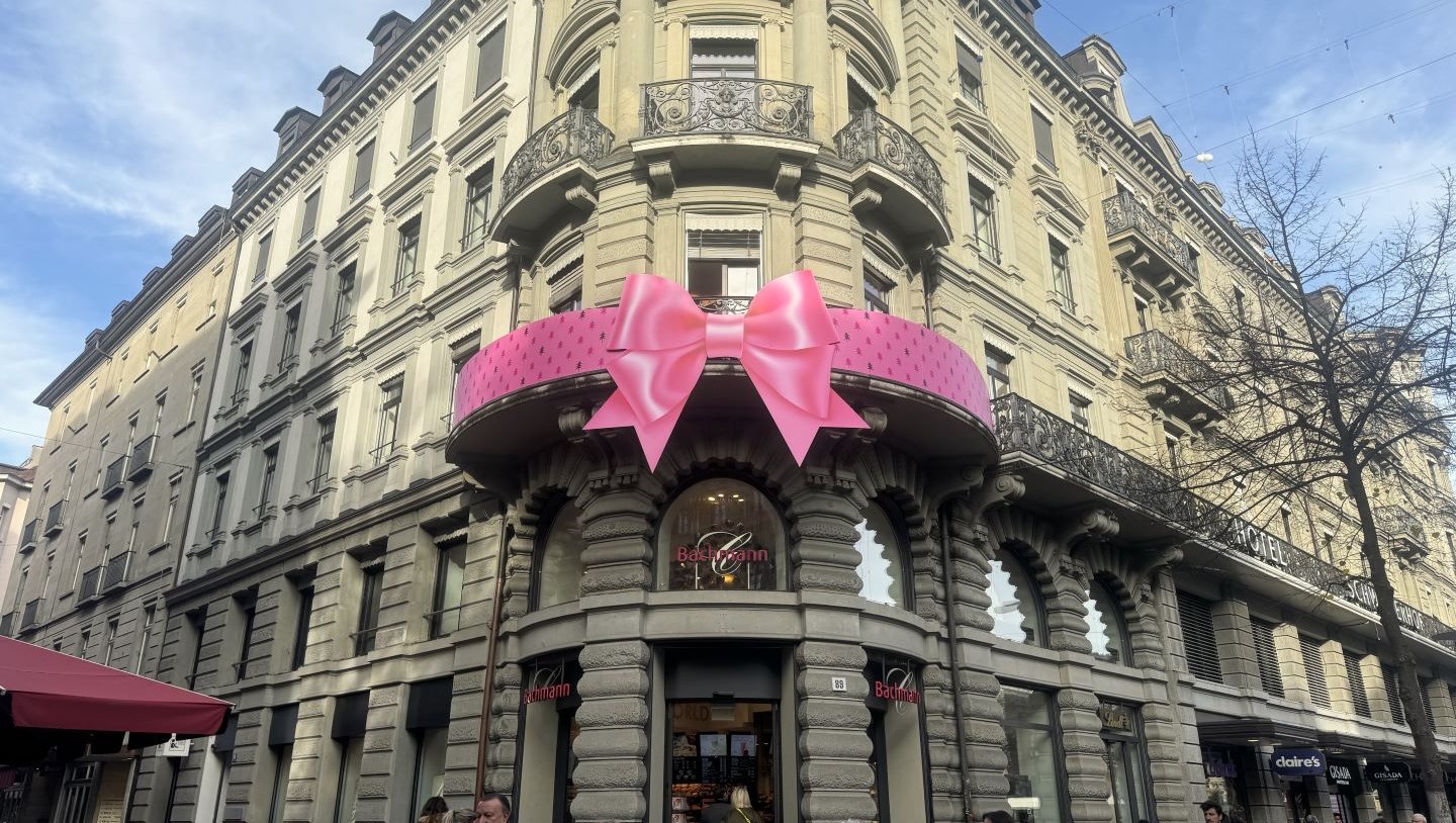 Rosa Riesenschleife am Balkongeländer des Flagship-Stores der Confiserie Bachmann in Zürich
